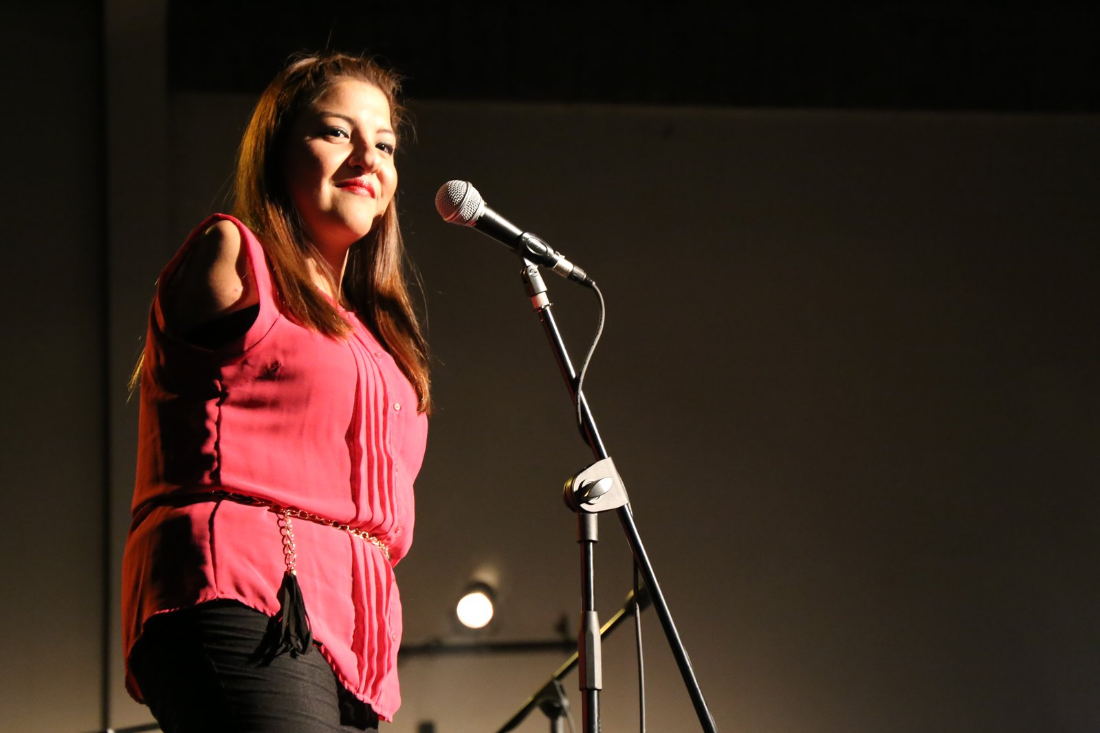 Antonella sonriendo frente a un micrófono en un escenario